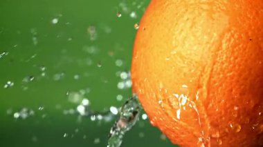 Olgun bir portakaldan su damlıyor. 1000 fps 'de yüksek hızlı bir kamerayla çekildi. Yüksek kaliteli FullHD görüntüler
