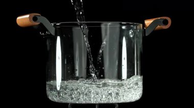 Su bir tencereye dökülür. 1000 fps 'de yüksek hızlı bir kamerayla çekildi. Yüksek kaliteli FullHD görüntüler