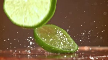 Limon dilimleri ahşap bir masaya düşer. 1000 fps 'de yüksek hızlı bir kamerayla çekildi. Yüksek kaliteli FullHD görüntüler