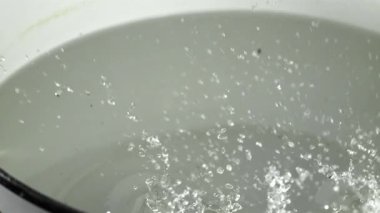 Patatesler tencereye düşer. 1000 fps 'de yüksek hızlı bir kamerayla çekildi. Yüksek kaliteli FullHD görüntüler