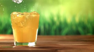 Buz küpleri portakal suyuna düşer. 1000 fps 'de yüksek hızlı bir kamerayla çekildi. Yüksek kaliteli FullHD görüntüler