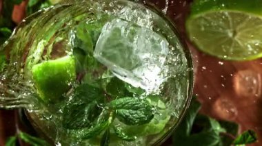 Buz mojito kokteyline düşer. 1000 fps 'de yüksek hızlı bir kamerayla çekildi. Yüksek kaliteli FullHD görüntüler