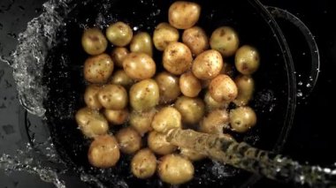 Su taze patateslerin üzerine dökülür. 1000 fps 'de yüksek hızlı bir kamerayla çekildi. Yüksek kaliteli FullHD görüntüler