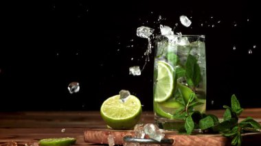 Buz mojito kokteyline düşer. 1000 fps 'de yüksek hızlı bir kamerayla çekildi. Yüksek kaliteli FullHD görüntüler