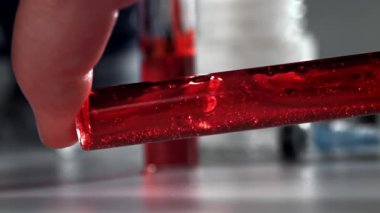 Doktorlarda test tüpündeki kan. 1000 fps 'de yüksek hızlı bir kamerayla çekildi. Yüksek kaliteli FullHD görüntüler
