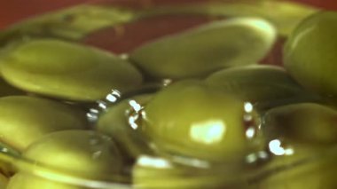 Zeytinler bir bardak yağın içine düşer. 1000 fps 'de yüksek hızlı bir kamerayla çekildi. Yüksek kaliteli FullHD görüntüler