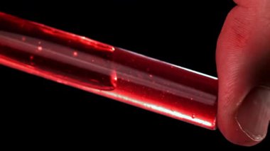 Doktorlarda test tüpündeki kan. 1000 fps 'de yüksek hızlı bir kamerayla çekildi. Yüksek kaliteli FullHD görüntüler