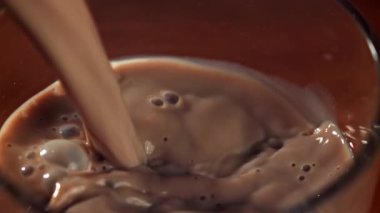 Sıcak çikolata bardağa dökülür. 1000 fps 'de yüksek hızlı bir kamerayla çekildi. Yüksek kaliteli FullHD görüntüler