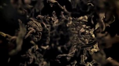 Kuru çay yaprakları dökülüyor. 1000 fps 'de yüksek hızlı bir kamerayla çekildi. Yüksek kaliteli FullHD görüntüler