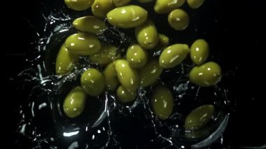 Zeytinler yağın içine düşer. 1000 fps 'de yüksek hızlı bir kamerayla çekildi. Yüksek kaliteli FullHD görüntüler