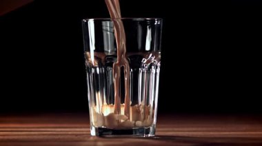 Sıcak çikolata bardağa dökülür. 1000 fps 'de yüksek hızlı bir kamerayla çekildi. Yüksek kaliteli FullHD görüntüler