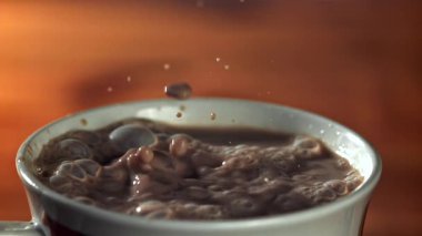 Bir damla sıcak çikolatanın içine düşer. 1000 fps 'de yüksek hızlı bir kamerayla çekildi. Yüksek kaliteli FullHD görüntüler