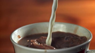 Süt sıcak çikolatanın içine dökülür. 1000 fps 'de yüksek hızlı bir kamerayla çekildi. Yüksek kaliteli FullHD görüntüler
