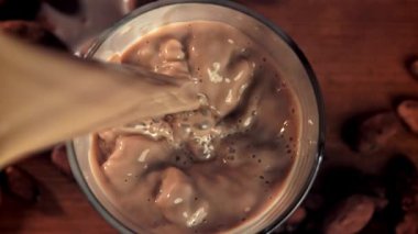 Sıcak çikolata bardağa dökülür. 1000 fps 'de yüksek hızlı bir kamerayla çekildi. Yüksek kaliteli FullHD görüntüler