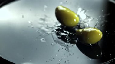 Zeytinler su sıçraması ile masaya düşer. 1000 fps 'de yüksek hızlı bir kamerayla çekildi. Yüksek kaliteli FullHD görüntüler