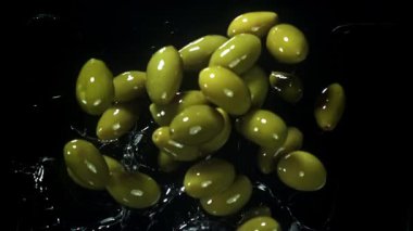Zeytinler yağın içine düşer. 1000 fps 'de yüksek hızlı bir kamerayla çekildi. Yüksek kaliteli FullHD görüntüler