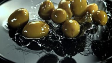 Zeytinler su sıçraması ile masaya düşer. 1000 fps 'de yüksek hızlı bir kamerayla çekildi. Yüksek kaliteli FullHD görüntüler