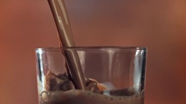 Sıcak çikolata bardağa dökülür. 1000 fps 'de yüksek hızlı bir kamerayla çekildi. Yüksek kaliteli FullHD görüntüler
