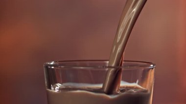 Sıcak çikolata bardağa dökülür. 1000 fps 'de yüksek hızlı bir kamerayla çekildi. Yüksek kaliteli FullHD görüntüler