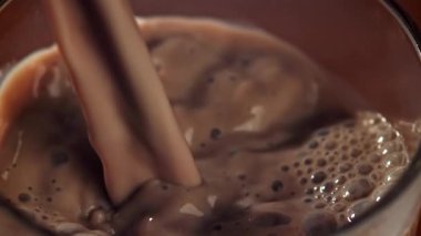 Sıcak çikolata bardağa dökülür. 1000 fps 'de yüksek hızlı bir kamerayla çekildi. Yüksek kaliteli FullHD görüntüler