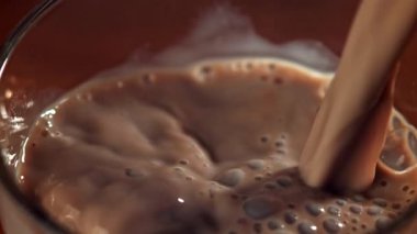 Sıcak çikolata bardağa dökülür. 1000 fps 'de yüksek hızlı bir kamerayla çekildi. Yüksek kaliteli FullHD görüntüler