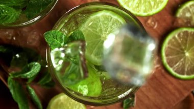 Buz mojito kokteyline düşer. 1000 fps 'de yüksek hızlı bir kamerayla çekildi. Yüksek kaliteli FullHD görüntüler