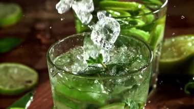 Buz mojito kokteyline düşer. 1000 fps 'de yüksek hızlı bir kamerayla çekildi. Yüksek kaliteli FullHD görüntüler