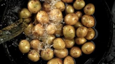 Su taze patateslerin üzerine dökülür. 1000 fps 'de yüksek hızlı bir kamerayla çekildi. Yüksek kaliteli FullHD görüntüler