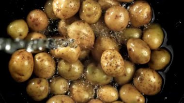 Su taze patateslerin üzerine dökülür. 1000 fps 'de yüksek hızlı bir kamerayla çekildi. Yüksek kaliteli FullHD görüntüler