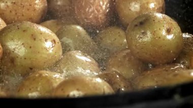 Patatesler büyük bir kızartma tavasında kızartılıyor. 1000 fps 'de yüksek hızlı bir kamerayla çekildi. Yüksek kaliteli FullHD görüntüler