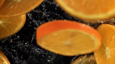 Dilimlenmiş turuncu daireler suya düşer. 1000 fps 'de yüksek hızlı bir kamerayla çekildi. Yüksek kaliteli FullHD görüntüler