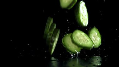 Dilimlenmiş salatalıklar masaya düşer. 1000 fps 'de yüksek hızlı bir kamerayla çekildi. Yüksek kaliteli FullHD görüntüler