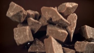 Çikolata parçaları erimiş çikolatanın içine düşer. 1000 fps 'de yüksek hızlı bir kamerayla çekildi. Yüksek kaliteli FullHD görüntüler