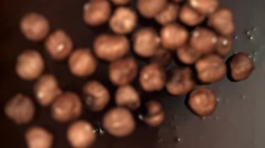 Fındıklar sıvı çikolatanın içine düşer. 1000 fps 'de yüksek hızlı bir kamerayla çekildi. Yüksek kaliteli FullHD görüntüler