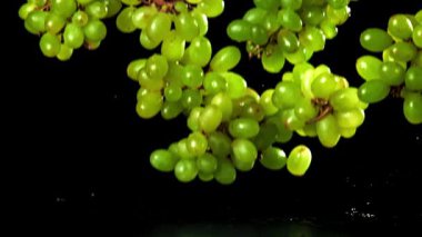 Yeşil üzümler masaya düşer. 1000 fps 'de yüksek hızlı bir kamerayla çekildi. Yüksek kaliteli FullHD görüntüler