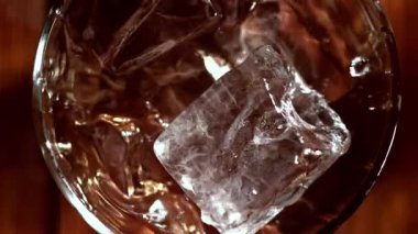 Buz bir bardak viskinin içine düşer. 1000 fps 'de yüksek hızlı bir kamerayla çekildi. Yüksek kaliteli FullHD görüntüler