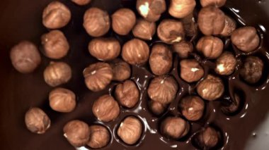 Fındıklar sıvı çikolatanın içine düşer. 1000 fps 'de yüksek hızlı bir kamerayla çekildi. Yüksek kaliteli FullHD görüntüler