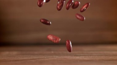 Kırmızı fasulyeler masaya düşer. 1000 fps 'de yüksek hızlı bir kamerayla çekildi. Yüksek kaliteli FullHD görüntüler