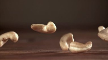 Kaju fıstıkları ahşap bir masaya düşer. 1000 fps 'de yüksek hızlı bir kamerayla çekildi. Yüksek kaliteli FullHD görüntüler