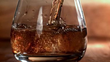Viski buzlu bir bardağa dökülür. 1000 fps 'de yüksek hızlı bir kamerayla çekildi. Yüksek kaliteli FullHD görüntüler