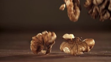 Cevizler ahşap bir masaya düşer. 1000 fps 'de yüksek hızlı bir kamerayla çekildi. Yüksek kaliteli FullHD görüntüler