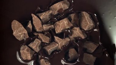 Çikolata parçaları erimiş çikolatanın içine düşer. 1000 fps 'de yüksek hızlı bir kamerayla çekildi. Yüksek kaliteli FullHD görüntüler