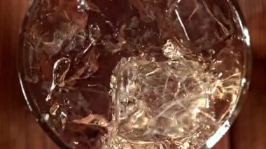 Buz bir bardak viskinin içine düşer. 1000 fps 'de yüksek hızlı bir kamerayla çekildi. Yüksek kaliteli FullHD görüntüler