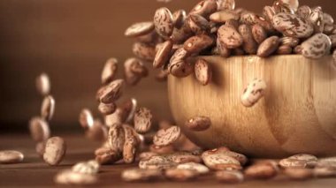 Beyaz fasulyeler ahşap bir kaba düşer. 1000 fps 'de yüksek hızlı bir kamerayla çekildi. Yüksek kaliteli FullHD görüntüler