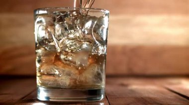 Viski buzlu bir bardağa dökülür. 1000 fps 'de yüksek hızlı bir kamerayla çekildi. Yüksek kaliteli FullHD görüntüler