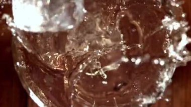 Buz bir bardak viskinin içine düşer. 1000 fps 'de yüksek hızlı bir kamerayla çekildi. Yüksek kaliteli FullHD görüntüler