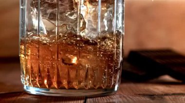 Viski buzlu bir bardağa dökülür. 1000 fps 'de yüksek hızlı bir kamerayla çekildi. Yüksek kaliteli FullHD görüntüler