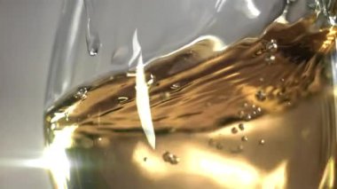 Bardakta beyaz şarap. 1000 fps 'de yüksek hızlı bir kamerayla çekildi. Yüksek kaliteli FullHD görüntüler