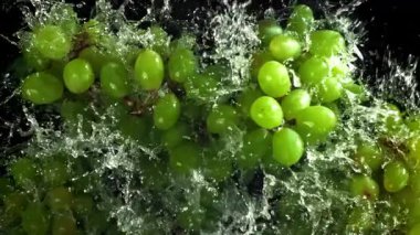 Yeşil üzümler suya düşer. 1000 fps 'de yüksek hızlı bir kamerayla çekildi. Yüksek kaliteli FullHD görüntüler