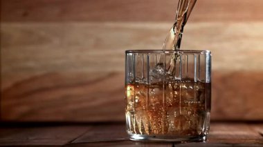 Viski buzlu bir bardağa dökülür. 1000 fps 'de yüksek hızlı bir kamerayla çekildi. Yüksek kaliteli FullHD görüntüler